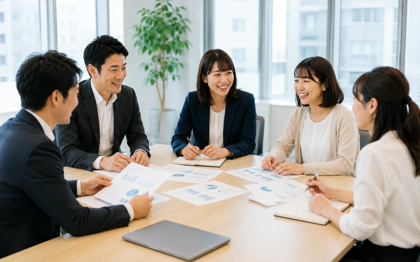 会議室で資料を囲んで話し合う社員たち