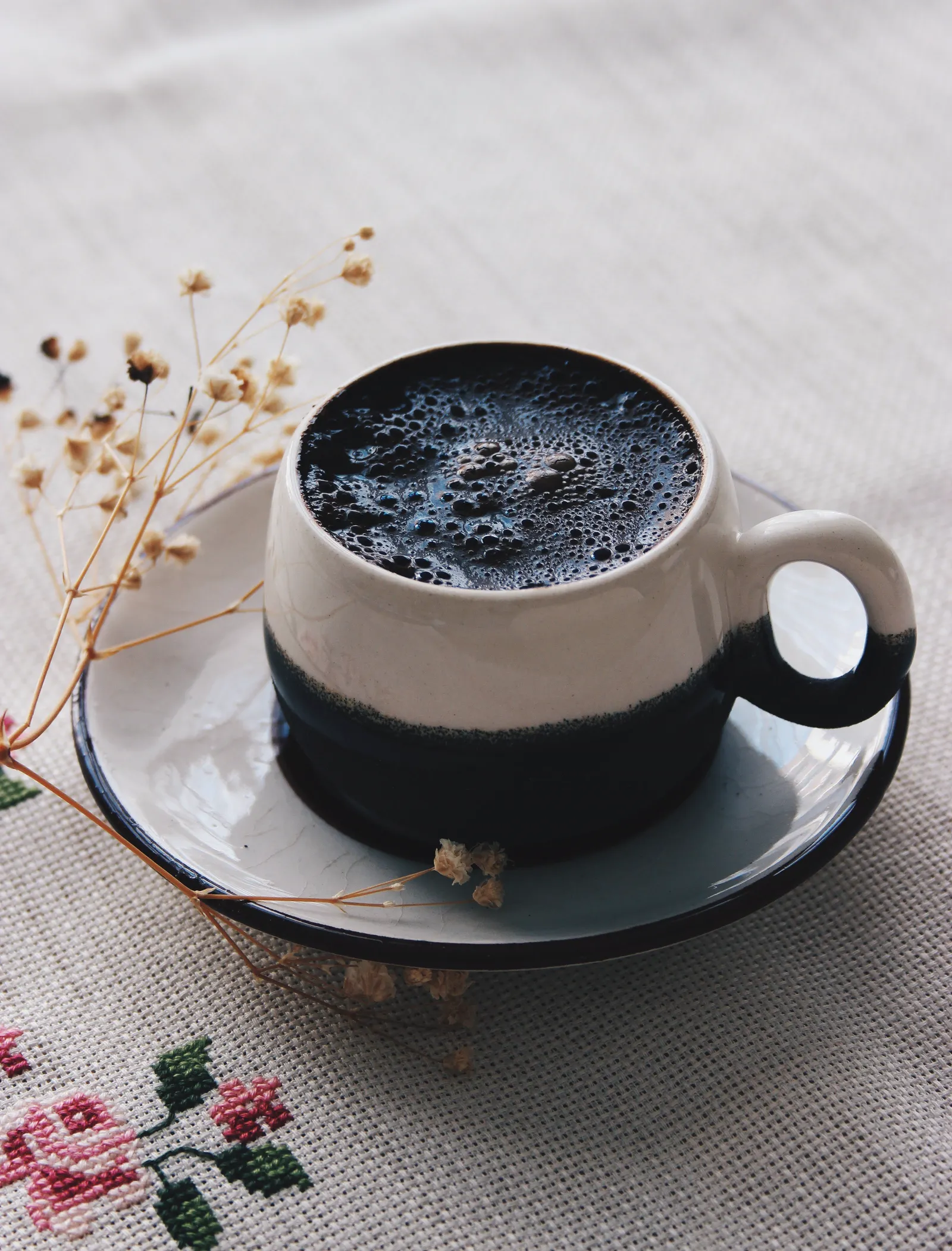 布の上に置かれた黒いコーヒーカップ